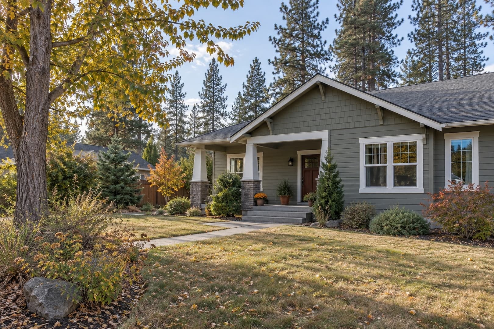 Craftsman-style home with a front porch and mature trees